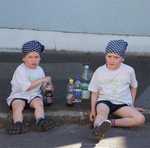 Kinder sitzen auf dem Gehsteig und warten auf den Start